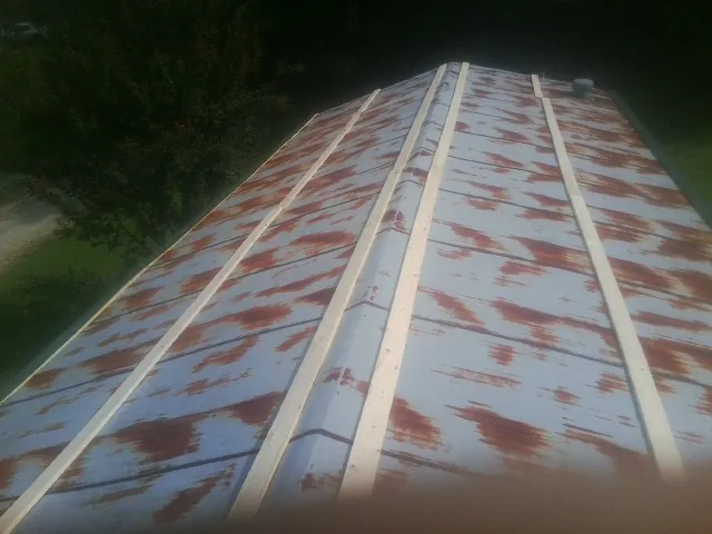 Rusted metal roof panels with new wood purlins before replacement — Storm Damage Roof Repair in Olin by Roofing Brothers